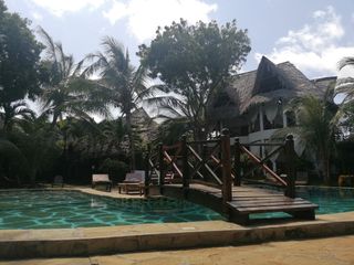 Pool und Villa mit Makuti-Dach